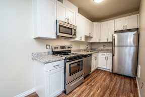 A kitchen with white cabinets and stainless steel appliances.