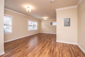 A room with wooden floors and two windows.