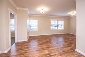 A room with wooden floors and two windows.