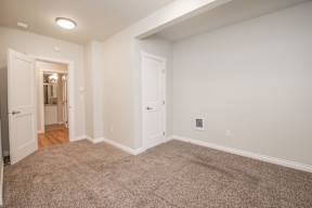 A room with carpeted floor and white walls.
