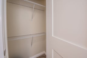 Empty white shelves in a white closet.