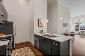 A modern kitchen with a black fridge and stove top oven.