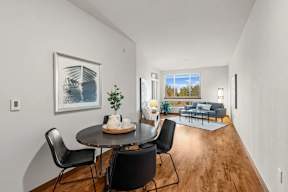 A dining room with a table and chairs.