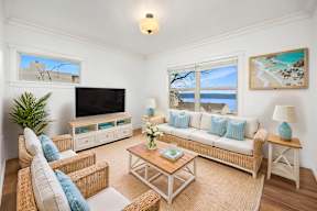 A living room with a sofa, chairs, and a television.