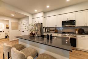 A modern kitchen with a long island and barstools.