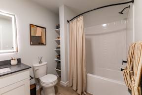 A bathroom with a toilet, sink, and shower.