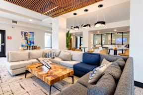 A modern living room with a wooden ceiling and a variety of seating options.