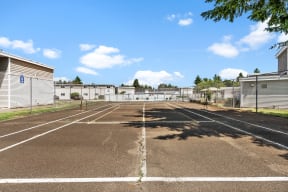 an empty parking lot with apartments in the background