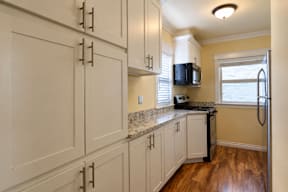 A kitchen with white cabinets and a granite countertop.