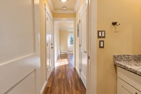 A long hallway with white walls and wood floors.