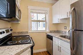 A kitchen with a stove top oven and a refrigerator.