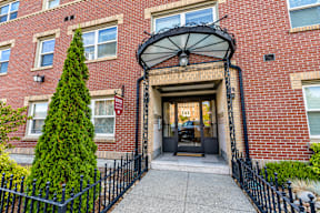 A red brick building with a black gate and a black umbrella above the entrance.