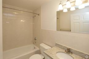A white bathroom with a toilet, sink, and bathtub.