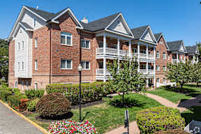 A large red brick building with a white trim and a black roof.