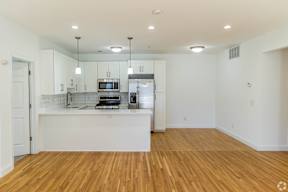 A kitchen with wooden floors and white walls.