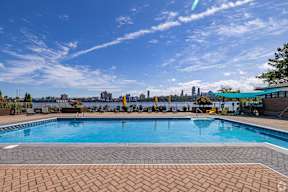 A swimming pool with a city skyline in the background.