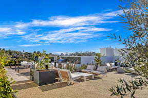 a roof terrace with furniture and a view of the city
