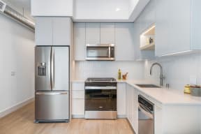 a kitchen with white cabinets and stainless steel appliances