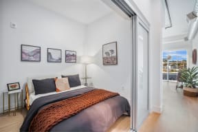 a bedroom with a bed and a sliding glass door to a balcony