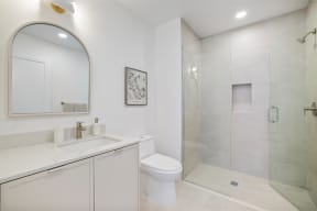 a white bathroom with a shower and a sink