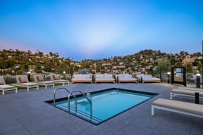 a swimming pool with lounge chairs and a mountain in the background