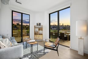 a living room with a couch and a chair and sliding glass doors to a balcony