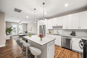 A modern kitchen with white cabinets and a center island.