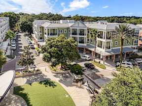 Aerial view of The Flats at Tioga Town Center courtyard and green apartment building in Newberry, FL.