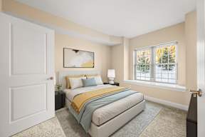 A bedroom with a bed, nightstand, and window.