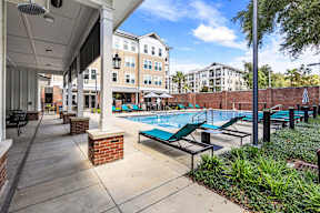 Resort-style pool with teal lounge chairs at The Flats at Tioga Town Center apartments in Newberry, FL.