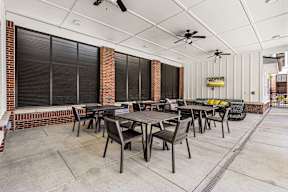 Covered patio with dining tables, lounge seating and ceiling fans at The Flats at Tioga Town Center.