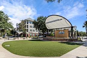 Performance stage and lawn near apartments at The Flats at Tioga Town Center in Newberry, FL.