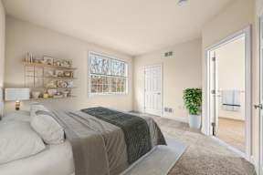 Bright bedroom with a large bed and a window that lets in natural light at Claremont Apartments in Exton, PA