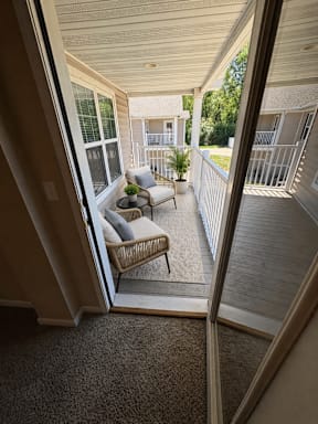 A balcony with a chair and a table.