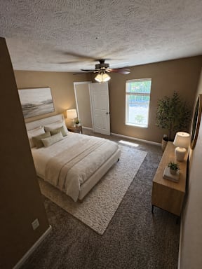 A bedroom with a bed, nightstand, and window.