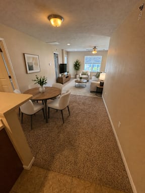 A living room with a dining table and chairs.