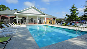 A pool with a white building behind it.