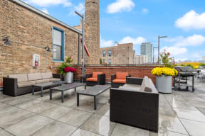 an outdoor patio with tables and chairs and a brick wall