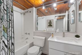 a bathroom with a toilet sink and a tub and a mirror