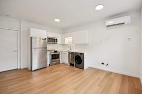 A kitchen with wooden floors and stainless steel appliances.