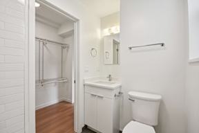 A white bathroom with a toilet, sink, and a shower.