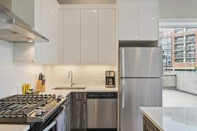 a kitchen with white cabinets and stainless steel appliances and a window