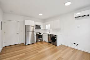 A kitchen with wooden floors and white walls.