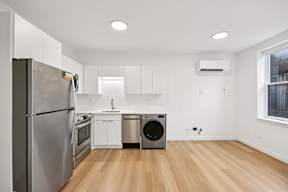 A modern kitchen with wooden floors and stainless steel appliances.
