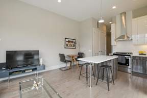 a kitchen and dining room with a white table and a tv