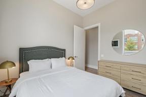 a bedroom with a large bed and a mirror on the wall