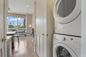 a washer and dryer in a laundry room with a view of the city