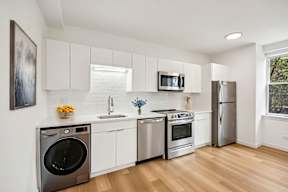 A modern kitchen with stainless steel appliances and white cabinets.