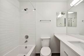 A white bathroom with a toilet, sink, and bathtub.