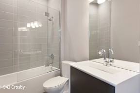 a white bathroom with a shower toilet and sink